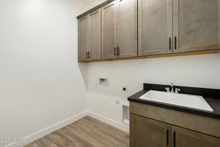 LAUNDRY ROOM WITH FULL UPPER CABINETS AND LAUNDRY SINK