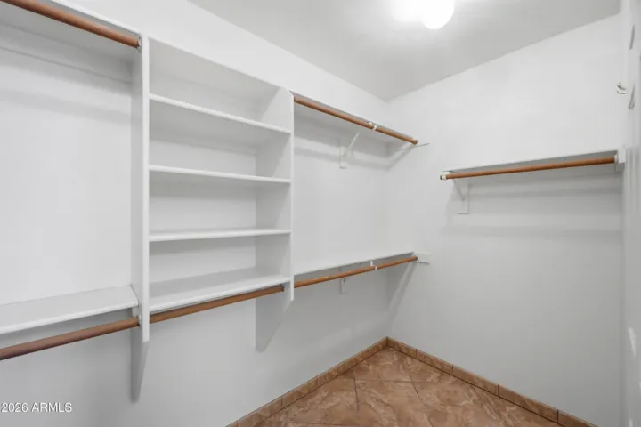 Spacious walk in closet with built in storage.