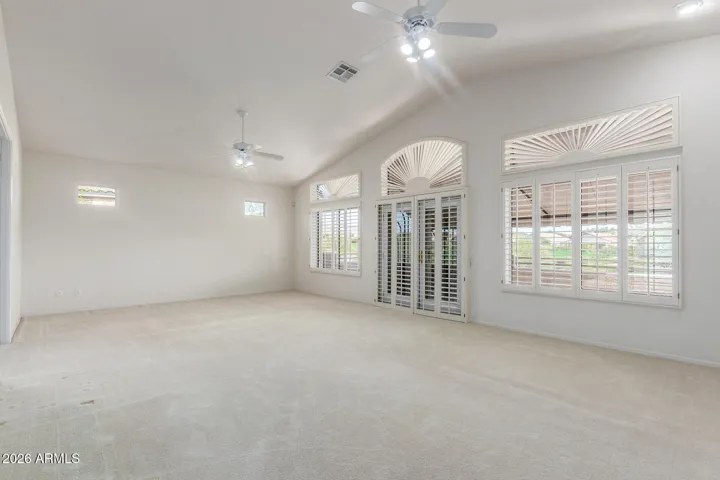 Enomous primmary bedroom with plantation shutters from front entrance to the room from. stairs.