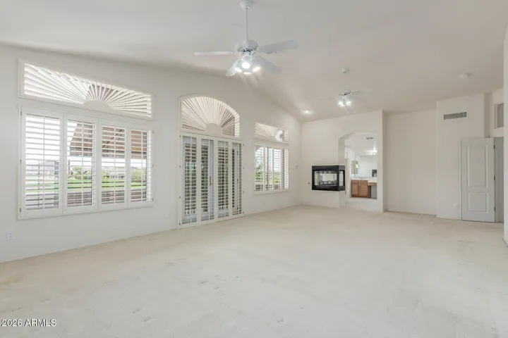 Primary bedroom with large balcony with double doors and plantation shutters.