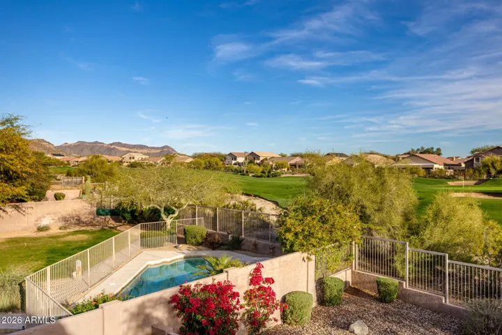 Back balcony view of golf course and mountains.