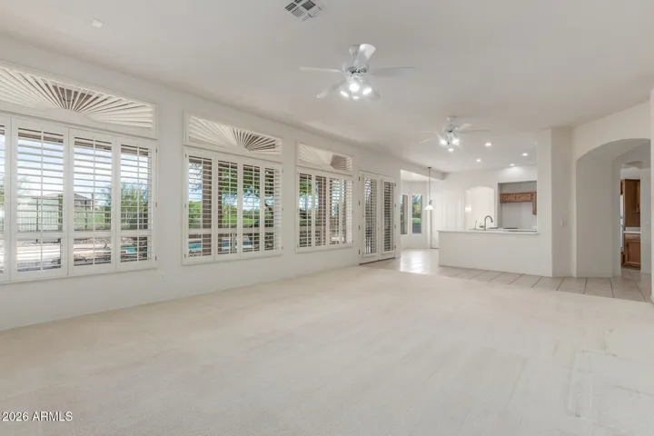 Immence beautiful living room space with large windows and plantation shutters.