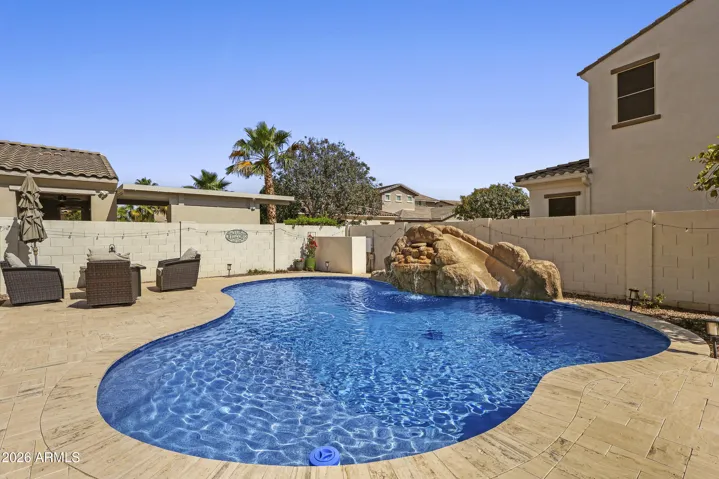 Great pool with water fall and slide, travertine surround