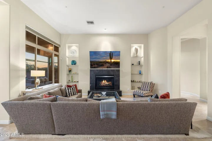 w/ lighted built-in shelving, gas fireplace, and access to the backyard
