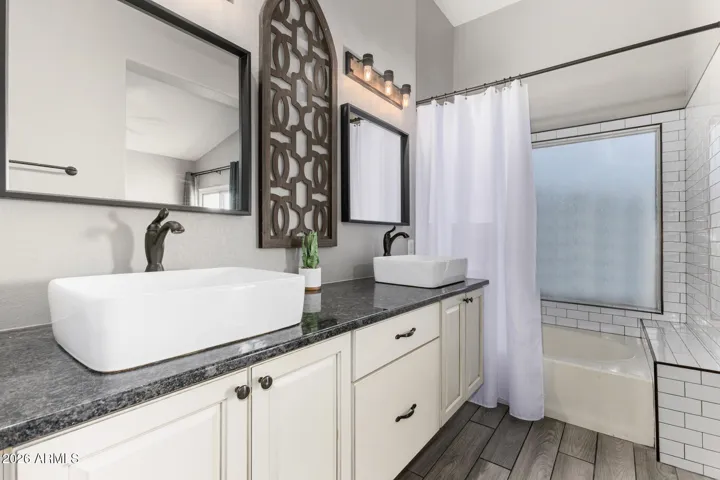 New Vanity with Double Vessel Sinks, Faucets, Toilet, Light Fixtures and Mirrors. New Timeless Subway Tile Shower Surround
