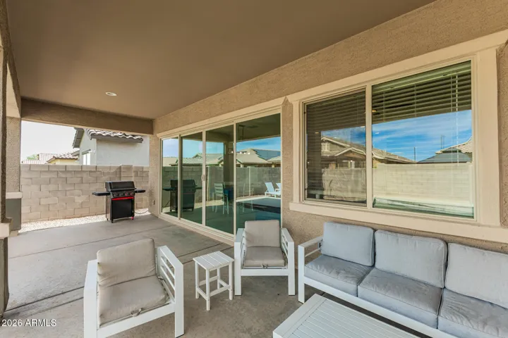 Spacious covered patio with sliding glass door access, ideal for indoor-outdoor entertaining in this Surprise home.