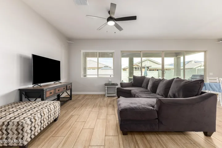 Light-filled great room with sliding glass doors overlooking the backyard and pool area, offering seamless indoor-outdoor living in Surprise.