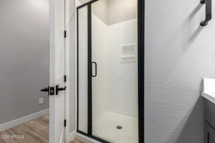 Clean and modern bathroom featuring walk-in shower with glass enclosure, updated fixtures, and easy-maintenance finishes in this Surprise home.