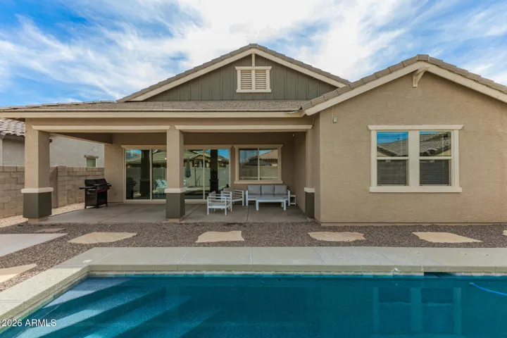 Low-maintenance backyard with gravel landscaping, stepping stones, and private pool, designed for easy outdoor living in Surprise.