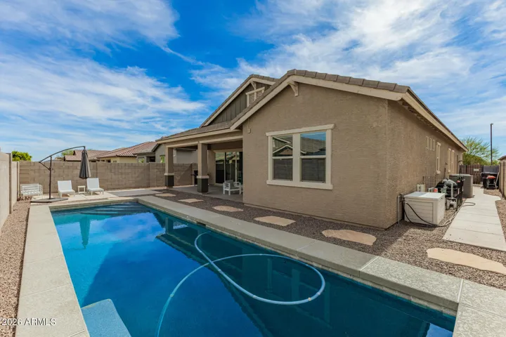 Backyard showcasing a long lap pool, desert landscaping, and plenty of room for outdoor enjoyment in this Surprise home.