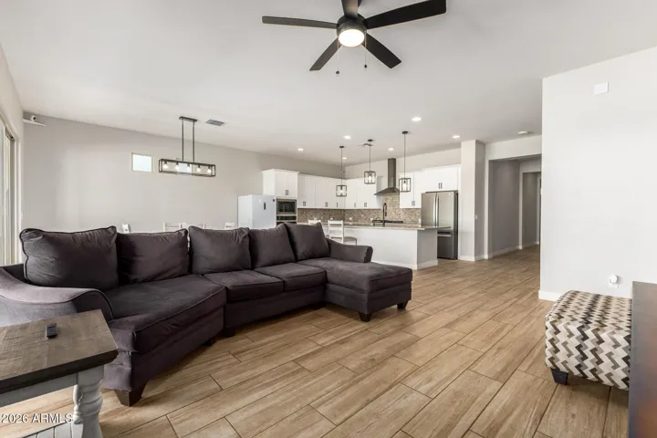Expansive great room with neutral tones, large windows, and open concept design, perfect for entertaining and everyday comfort in this Surprise home.