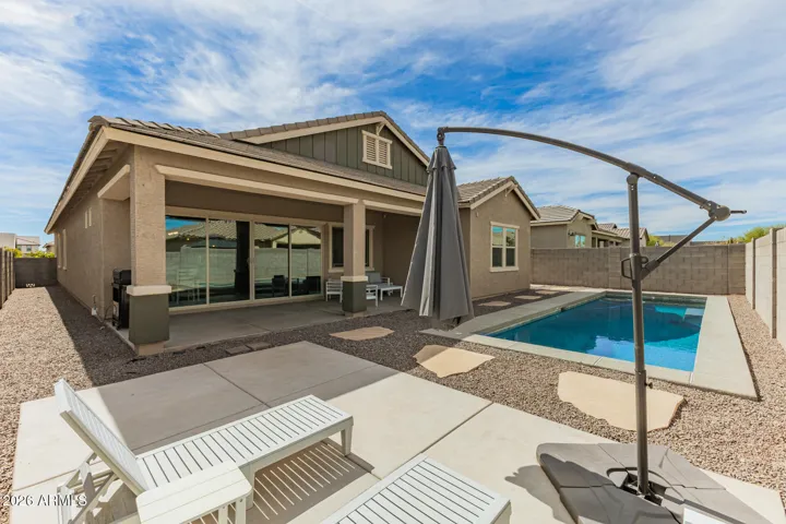 Private backyard featuring a sparkling pool, low-maintenance landscaping, and ample space for relaxing or entertaining in Surprise.
