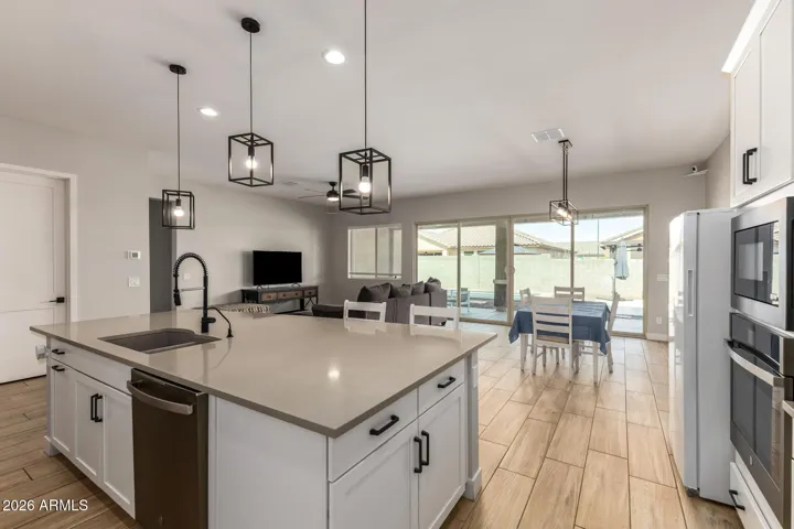 Oversized kitchen island with breakfast bar seating, quartz surfaces, and open layout, perfect for gatherings and everyday functionality in this Surprise home.