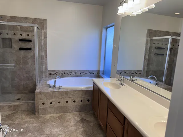 Primary bath with separate tub and shower and lots of counter space between double sinks.