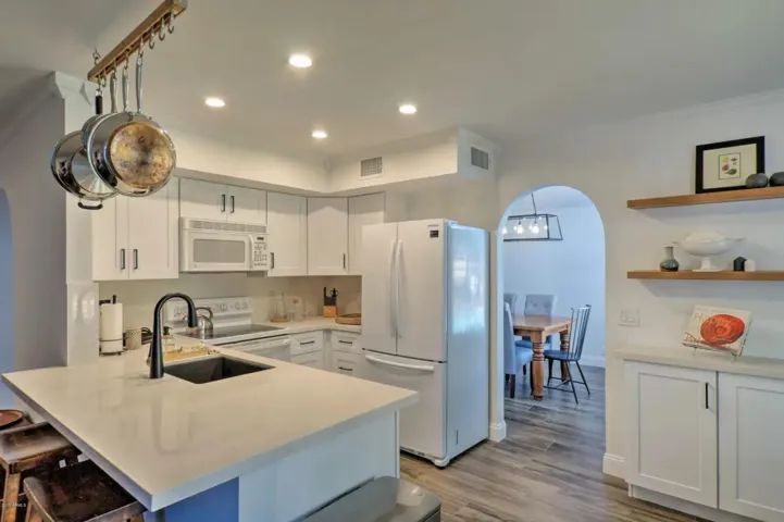 The kitchen features quartz countertops and can lighting.