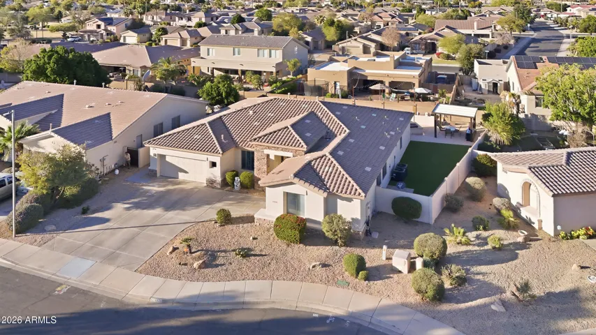 Aerial photo revealing the home's spacious layout and backyard outdoor living spaces. The image highlights the private yard, pool area, and gazebo entertaining space within this Goodyear property.
