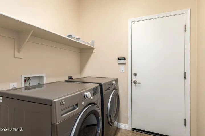 The laundry room is thoughtfully positioned with included washer and dryer and seamless access to the garage for added convenience.