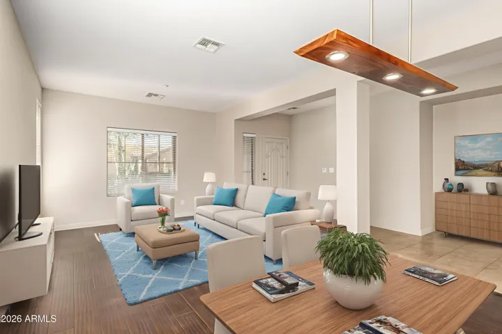 The formal living and dining room is illuminated by natural light that complements the dark wood floors and timeless neutral backdrop.