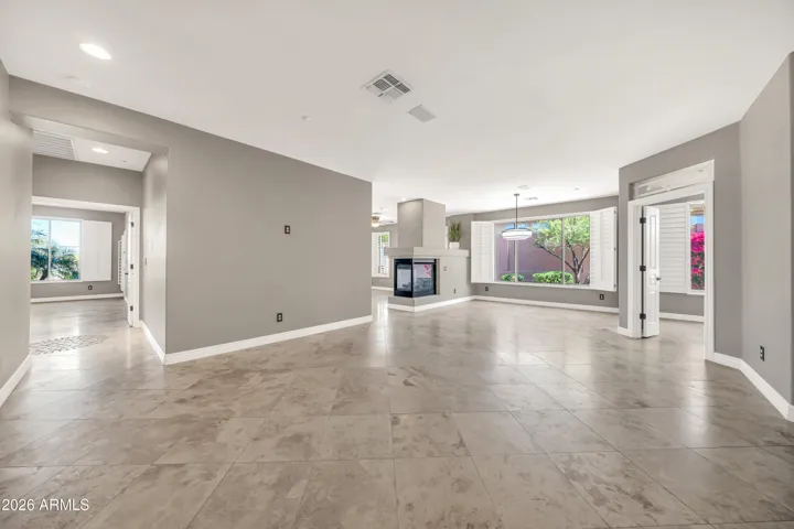 Main living with Primary suite hall to left, towards dining at center and office/den to right