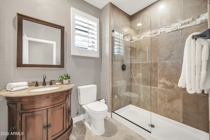 Guest bath with custom stone work in shower and custom sink cabinet