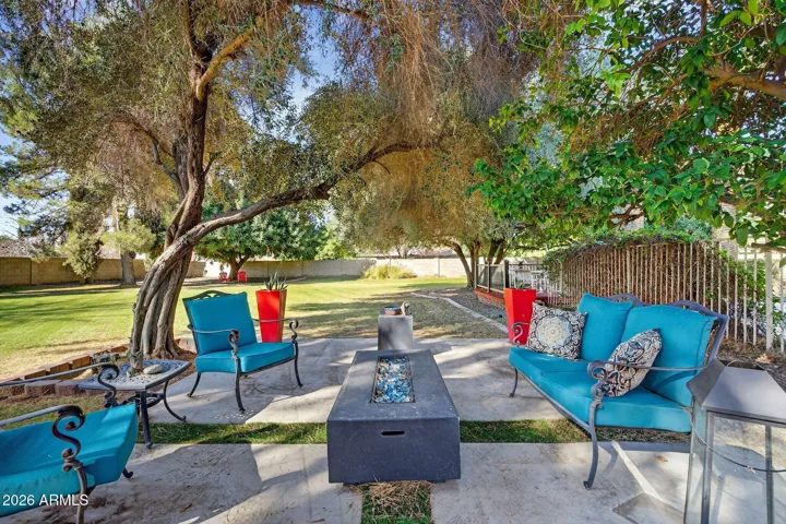 Green view patio nestled under 2 mature trees is the perfect spot for a firepit.
