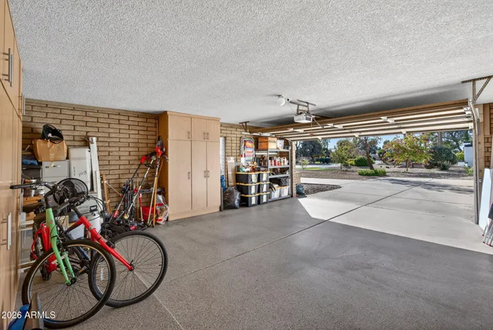 Side entry garage with work bench, storage cabinets, and epoxy flooring