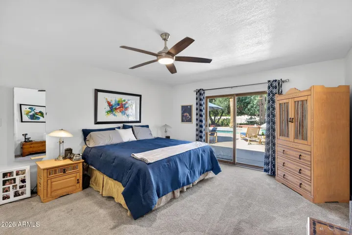 Spacious master with views to the pool area and backyard greenery.