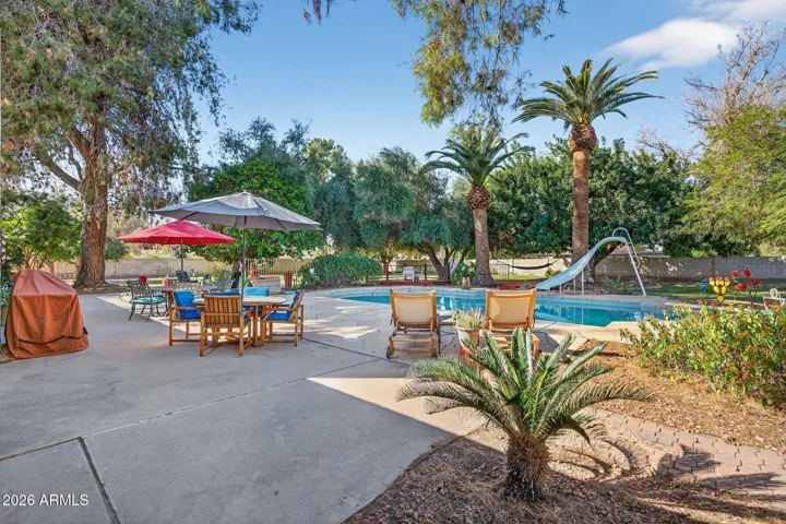 Resort style landscaped back yard, with pool, expansive green areas, mature trees, dining deck, hammock deck, and 60' patio.