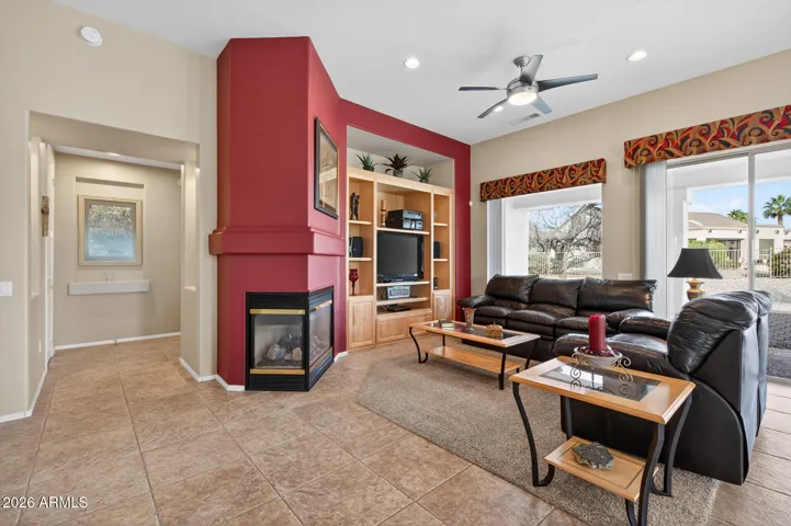 The Great Room features a custom wooden shelving unit and gas fireplace.
