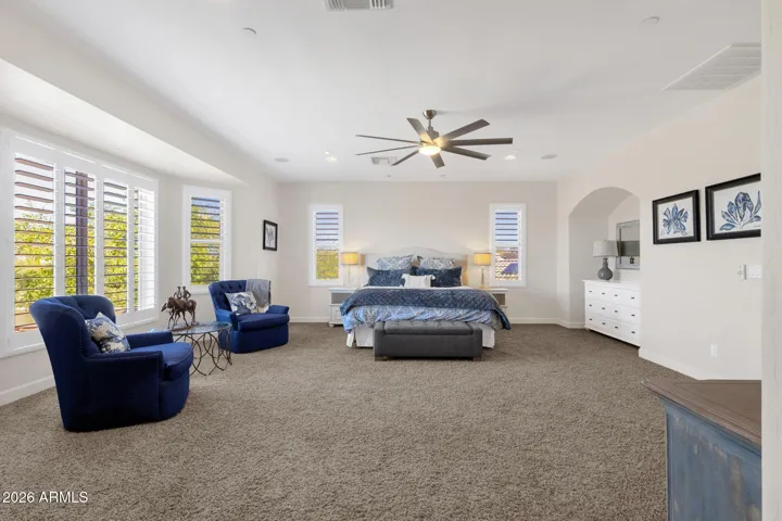 Primary suite with fireplace, sitting area and plantation shutters.