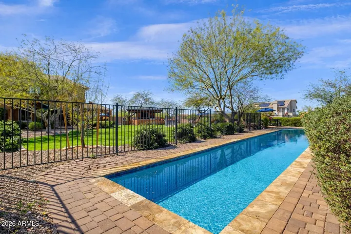 Pool area is surrounded by wrought iron, not by neighbors.