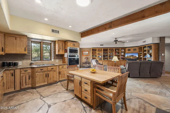 Well-appointed kitchen featuring extensive cabinetry, built-in oven, and a functional island that connects to the adjacent family room.