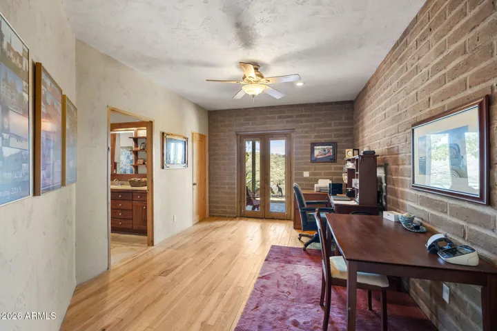 Versatile room with wood flooring and French doors leading outside, suitable for a home office or hobby space.