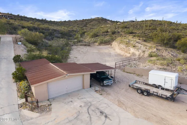 Separate garage structure with attached covered parking and ample space for trailers, recreational vehicles, or additional equipment.