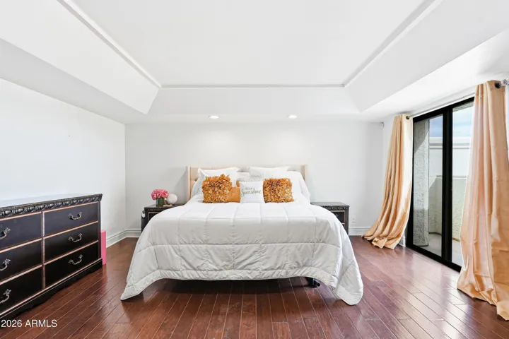 Relax in the primary suite with balcony overlooking twinkling city lights