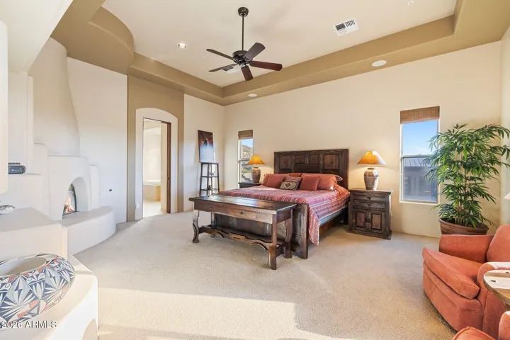 Primary suite with gas fireplace and access to patio.