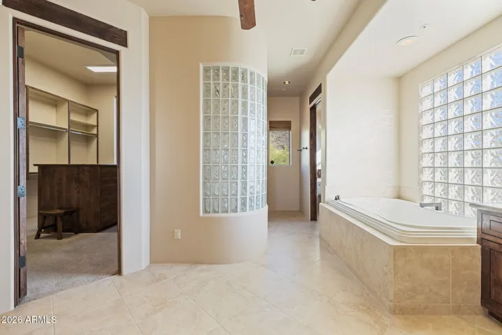 Primary bathroom with jetted tub, walk-in shower, twin vanities and extra large closet with safe.