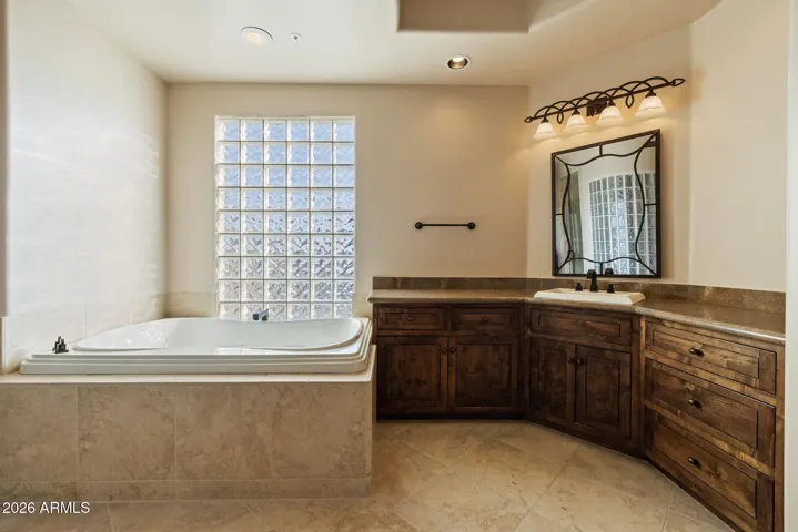 Primary bathroom with jetted tub, walk-in shower, twin vanities and extra large closet with safe.