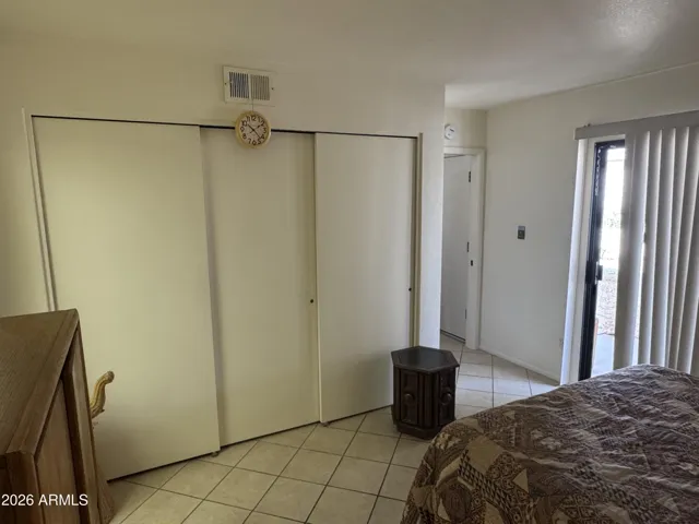 Triple closet and sliding door entry in bedroom