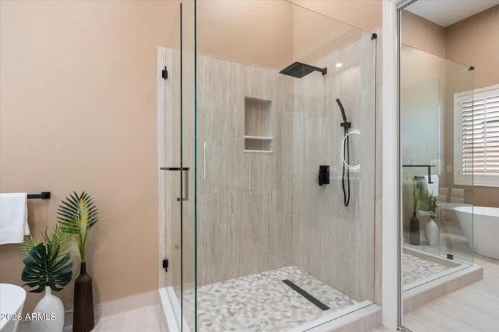 Sophisticated primary bath with soaking tub is fully remodeled from the flooring and new shower to the custom cabinets with lighted mirrors and new light fixtures.