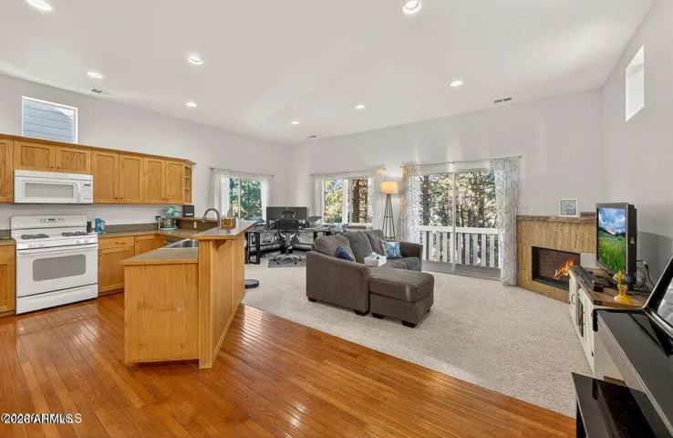 Gas Fireplace takes center stage with wall of windows overlooking lush forest
