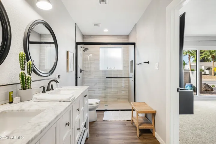 Primary bathroom with dual sinks, walk-in shower and spacious walk-in closet.