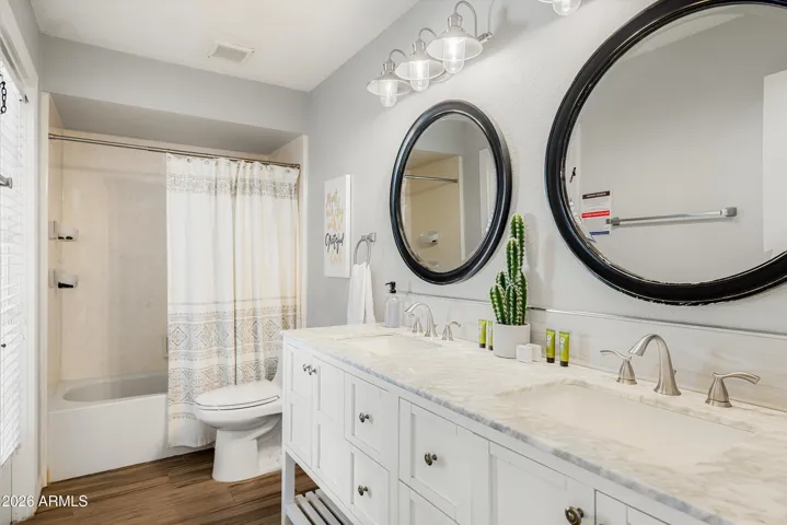 Hallway Bathroom with dual-sinks, bathtub and direct access to the backyard.