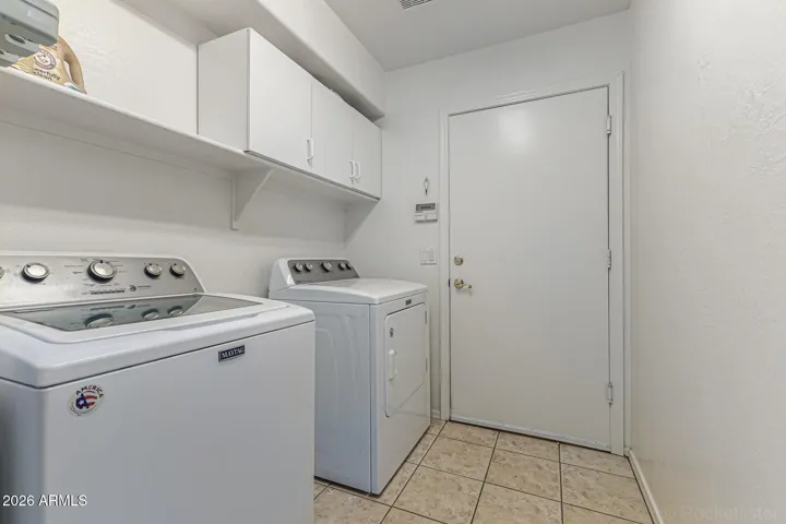 Laundry Space with shelving - both washer and dryer convey.
