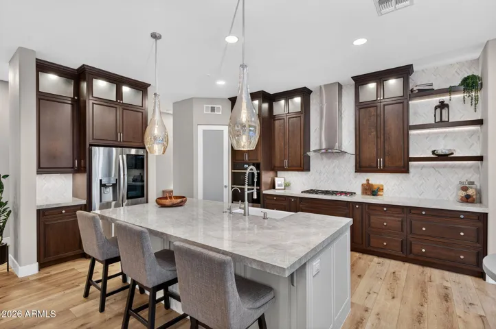 Modern gourmet kitchen featuring a large porcelain slab island, farmhouse sink, custom cabinetry, and high-end finishes throughout this Scottsdale home.
