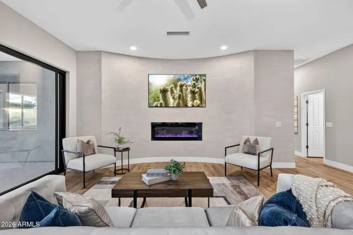 Stylish Scottsdale living room featuring a sleek linear fireplace, wood flooring, and contemporary seating, offering a warm and inviting space with modern updates.