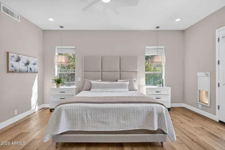 Light-filled Scottsdale primary suite with dual windows, designer lighting, and neutral tones, creating a serene and inviting space with modern updates.