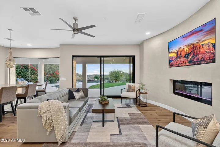 Bright Scottsdale living room featuring a modern linear fireplace, wood flooring, and large sliding doors connecting to the backyard for seamless indoor-outdoor living