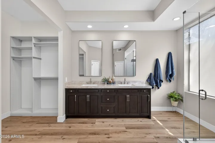 Scottsdale bathroom featuring dual sinks, porcelain slab countertops, and rich cabinetry, offering both style and convenience with updated finishes.