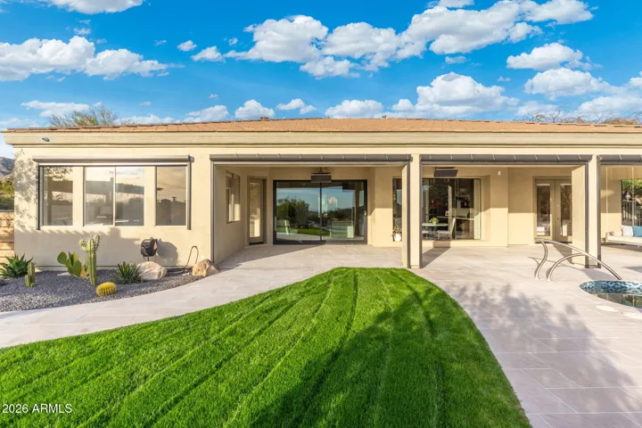 Scottsdale backyard with covered patio, lush green lawn, and seamless indoor-outdoor flow, perfect for entertaining and everyday living.